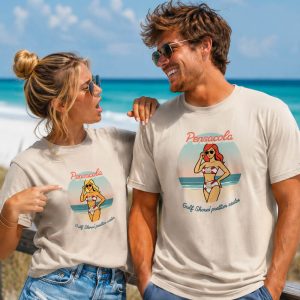 Nice looking couple in twenties from Pensacola on boardwalk. Blonde girl is wearing shirt reading "Pensacola - Gulf Shores' Prettier Sister" with a blonde woman on front and man is wearing same but with redhead on front. This creates friendly tension between them.